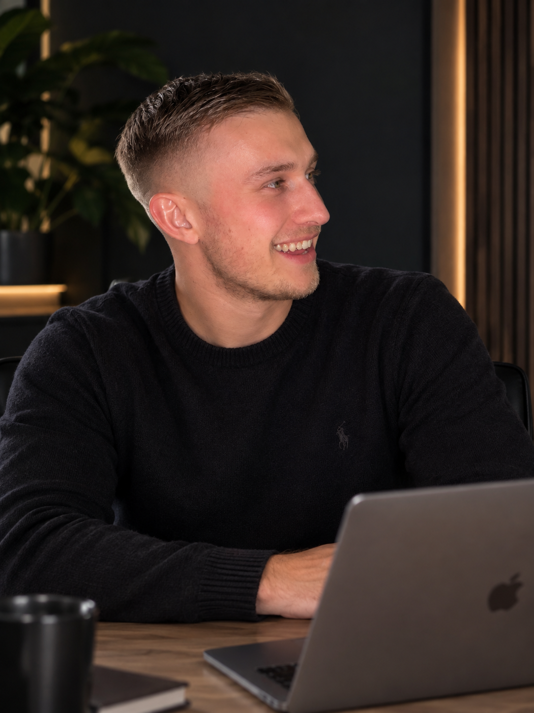Jorn, lachend aan tafel met zijn laptop